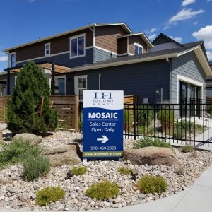 A homebuilder sign in front of a model home