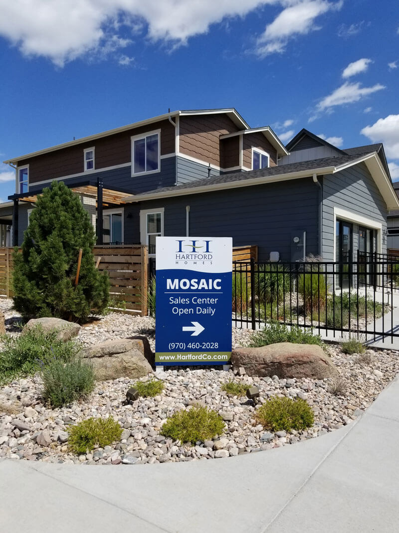 A homebuilder sign in front of a model home